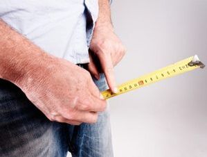 a man measures the length of the penis before enlargement with soda